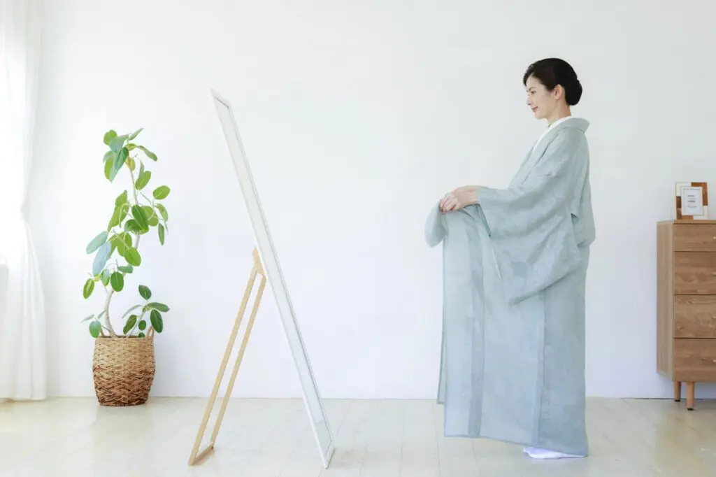 鏡の前で着物を着る女性