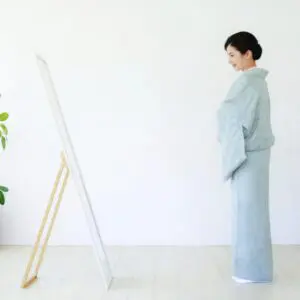 鏡の前で着付けをする女性