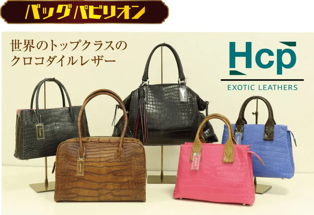 黒、茶、ピンク、赤、水色のワニ革ハンドバッグ5点がスタンドに並べられている。上部には日本語の文字とHCP EXOTIC LEATHERSのロゴが表示され、京都まるなか万博の最高級ワニ革を強調しています。.